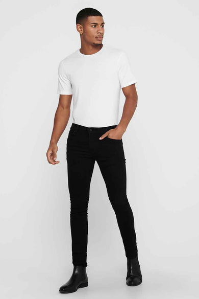Jean slim noir de ONLY & SONS®, porté avec un t-shirt blanc et des bottines noires.