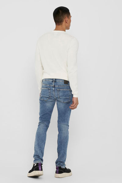 Jean slim bleu par ONLY & SONS, porté avec un pull blanc, vu de dos.