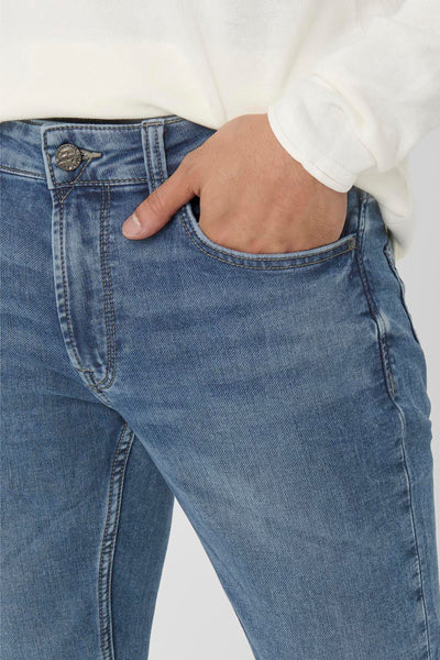 Blauwe slim fit jeans van ONLY & SONS, met de hand in de zak en een gebroken witte trui.