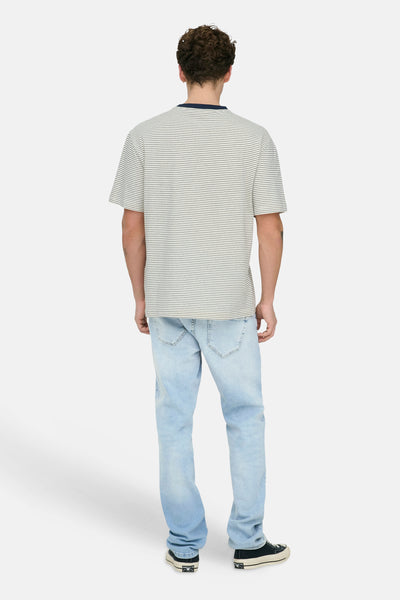 Light blue straight-leg jeans by WEFT, worn with striped tee and black sneakers, back view.