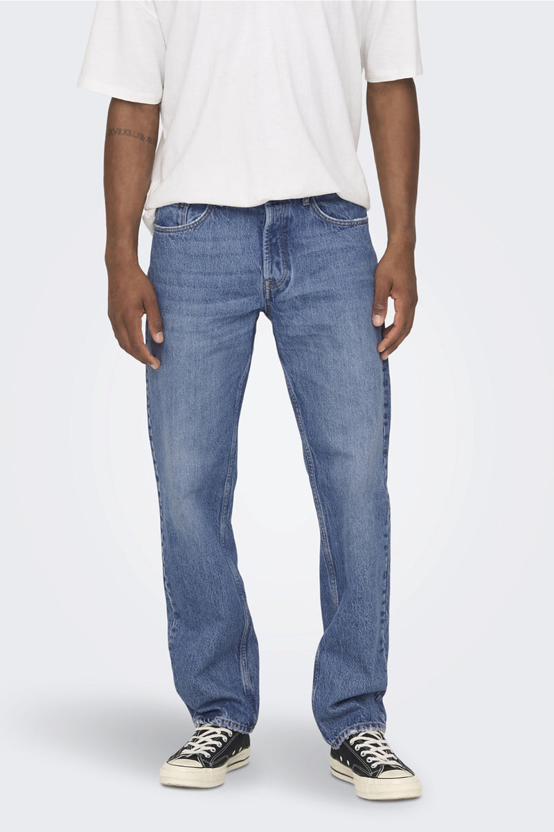 Jean large bleu de ONLY & SONS, porté avec un t-shirt blanc et des baskets noires.