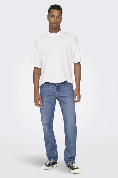 Jean large bleu de ONLY & SONS, porté avec un t-shirt blanc et des baskets noires.