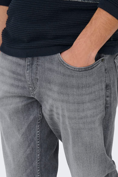 Lichtgrijze rechte jeans van ONLY & SONS®, met een hand in de zak, gedragen met een marineblauwe trui.