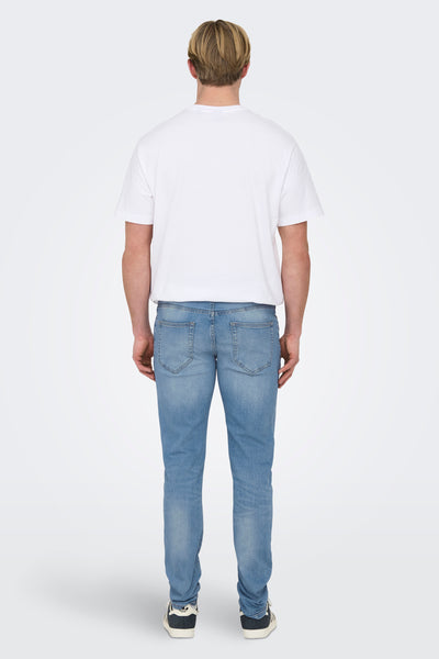 Jean slim en denim bleu clair de ONLY & SONS®, porté avec un t-shirt blanc et des baskets foncées, vue de dos.