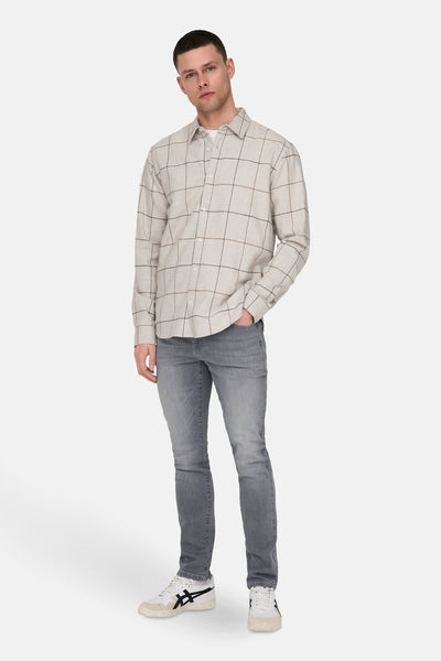 Slim jeans in lichtgrijs denim van ONLY & SONS, gedragen met een geruit overhemd.
