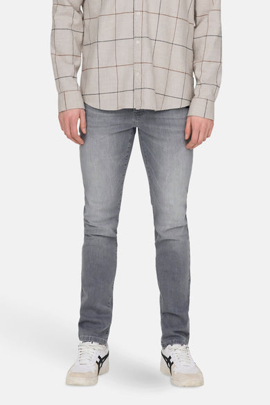 Slim jeans in lichtgrijs denim van ONLY & SONS, gedragen met een geruit overhemd en witte sneakers.
