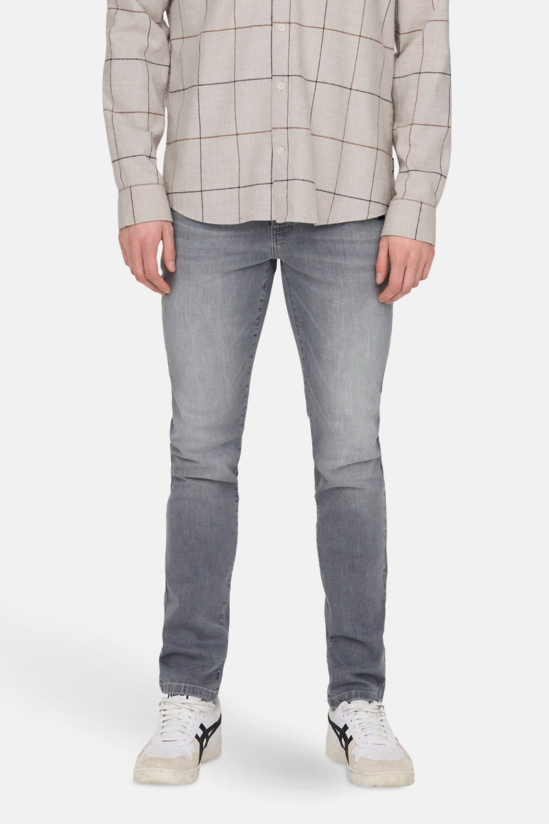 Slim jeans in lichtgrijs denim van ONLY & SONS, gedragen met een geruit overhemd en witte sneakers.