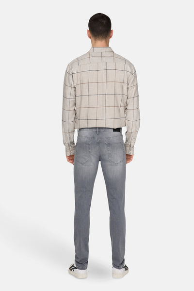 Slim jeans in lichtgrijs denim van ONLY & SONS, gedragen met een geruit overhemd.