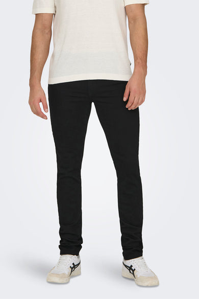 Jean slim noir de ONLY & SONS, porté avec un t-shirt blanc et des baskets blanches et noires.