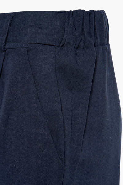 Navy blue shorts with elastic waistband and front pleats, close-up front view