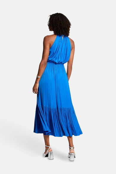 Robe bleue Morgan de Toi avec col montant et ourlet à volants, portée avec des talons argentés, vue de dos.