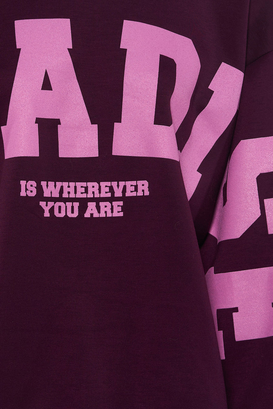 Multicolored crewneck sweatshirt with bold pink graphic text "ADY IS WHEREVER YOU ARE" on deep purple fabric, close-up front view