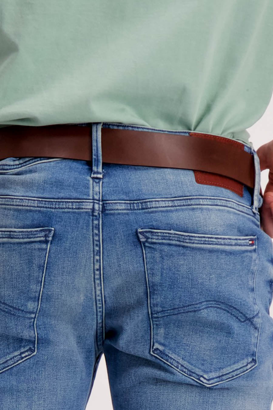 Ceinture marron de Levi's Accessories, portée avec un jean bleu et un t-shirt vert.
