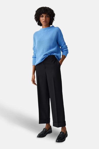 Pull à col rond bleu de OPUS, porté avec un pantalon noir et des mocassins noirs.