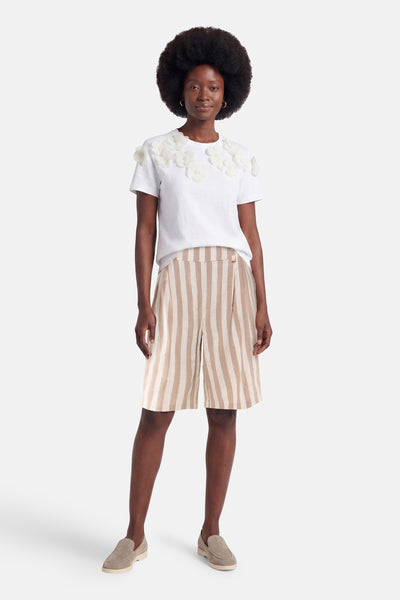 Beige striped women's shorts with elastic waist, front view, paired with white top featuring floral embellishments and beige loafers