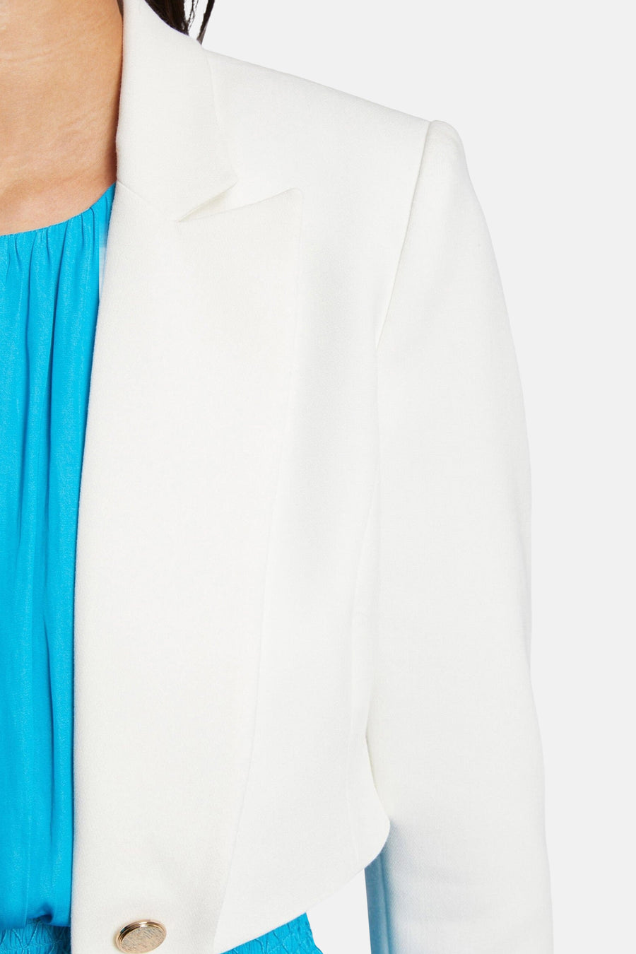 Veste écru par Morgan de Toi, avec un bouton doré sur le devant et une doublure bleu turquoise.
