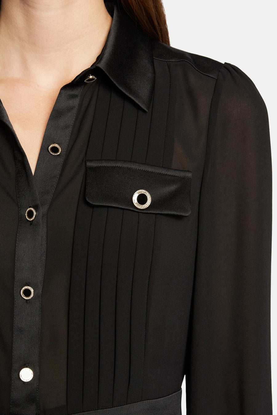 Black long-sleeve blouse with pleated front and embellished buttons, close-up view showing satin collar and chest pocket detail