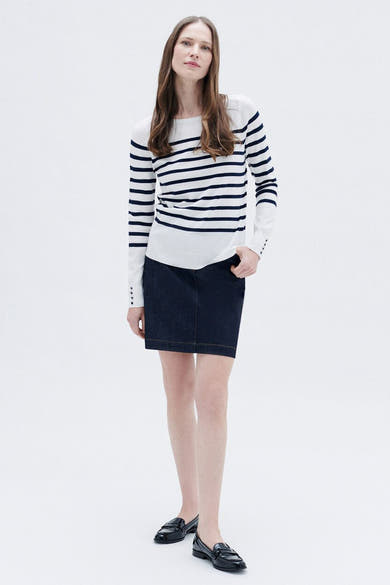 Rondhalsw shirt in CARru van CARoll,, met eenjejeu en en enpeen zwarte laarzen.