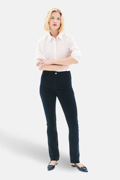 Blauwe broek van CAROLL, gedragen met een wit overhemd met knopen en donkere platte schoenen.