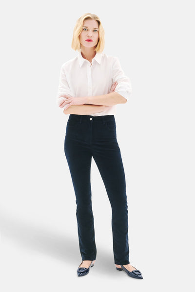 Blauwe broek van CAROLL, gedragen met een wit overhemd met knopen en donkere platte schoenen.
