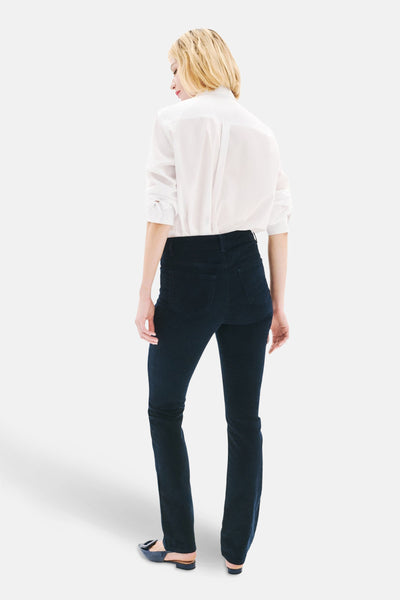 Pantalon bleu de CAROLL, coupe droite, porté avec une chemise blanche à manches longues.