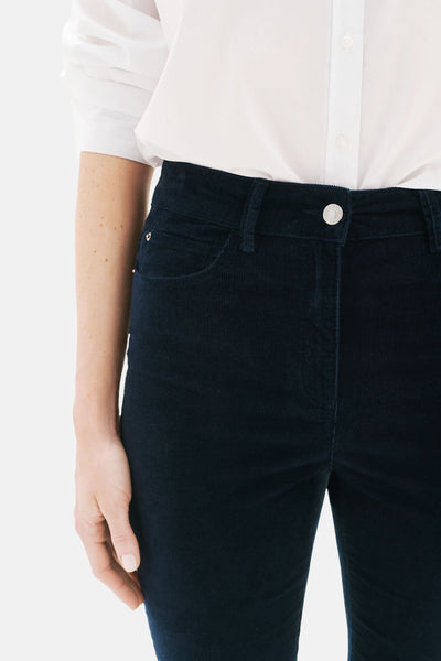 Pantalon bleu en velours côtelé de CAROLL, porté avec une chemise blanche, en gros plan.