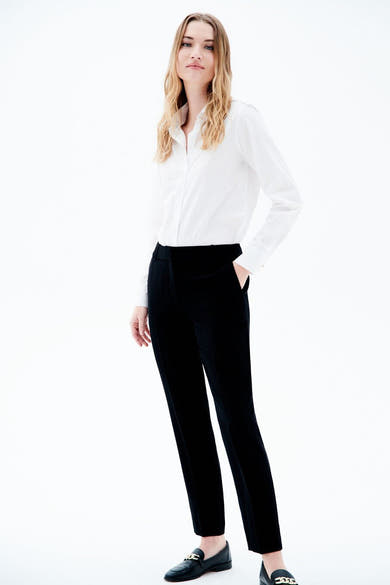 Pantalon de costume noir de CAROLL, porté avec une chemise blanche et des mocassins noirs.
