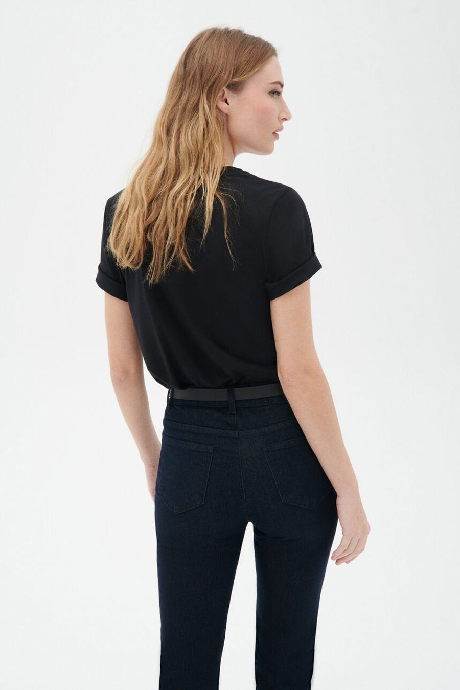 Zwart T-shirt met korte mouwen van CAROLL, gedragen met een jeans met hoge taille en een dunne riem.