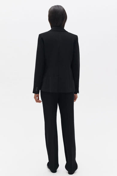 Blazer noir de CAROLL, porté avec un pantalon assorti, vue de dos.