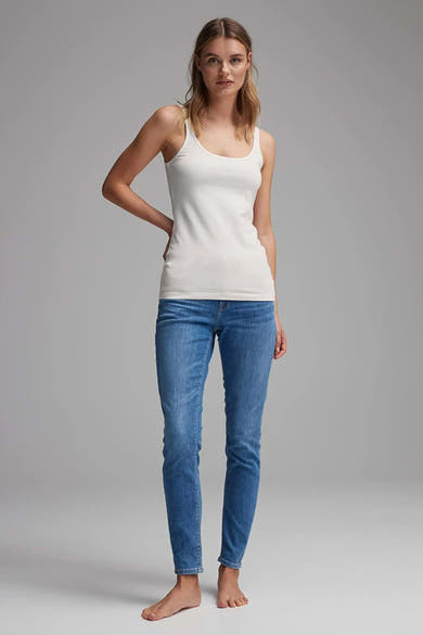 Débardeur blanc de OPUS porté avec un jean, manches et jambes nues.