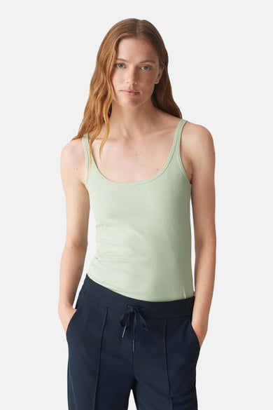 Débardeur vert clair d'OPUS, porté avec un pantalon de survêtement bleu marine à cordon de serrage.