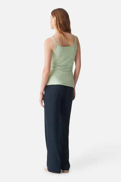 Top vert à fines bretelles de OPUS, porté avec un pantalon bleu marine ample, vue de dos.