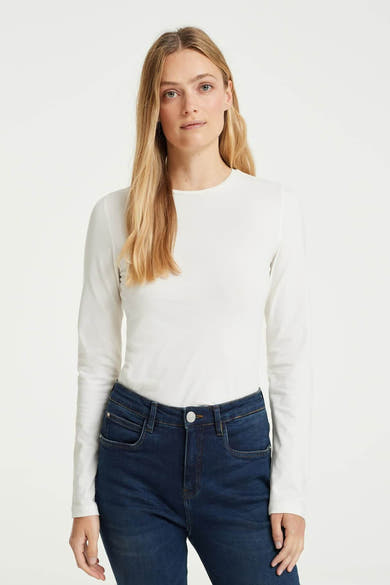 T-shirt à manches longues blanc d'OPUS, porté avec un jean bleu foncé taille haute.
