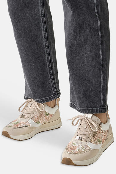 Beige Tamaris sneakers met een delicaat bloemenpatroon en een decoratieve ritssluiting.