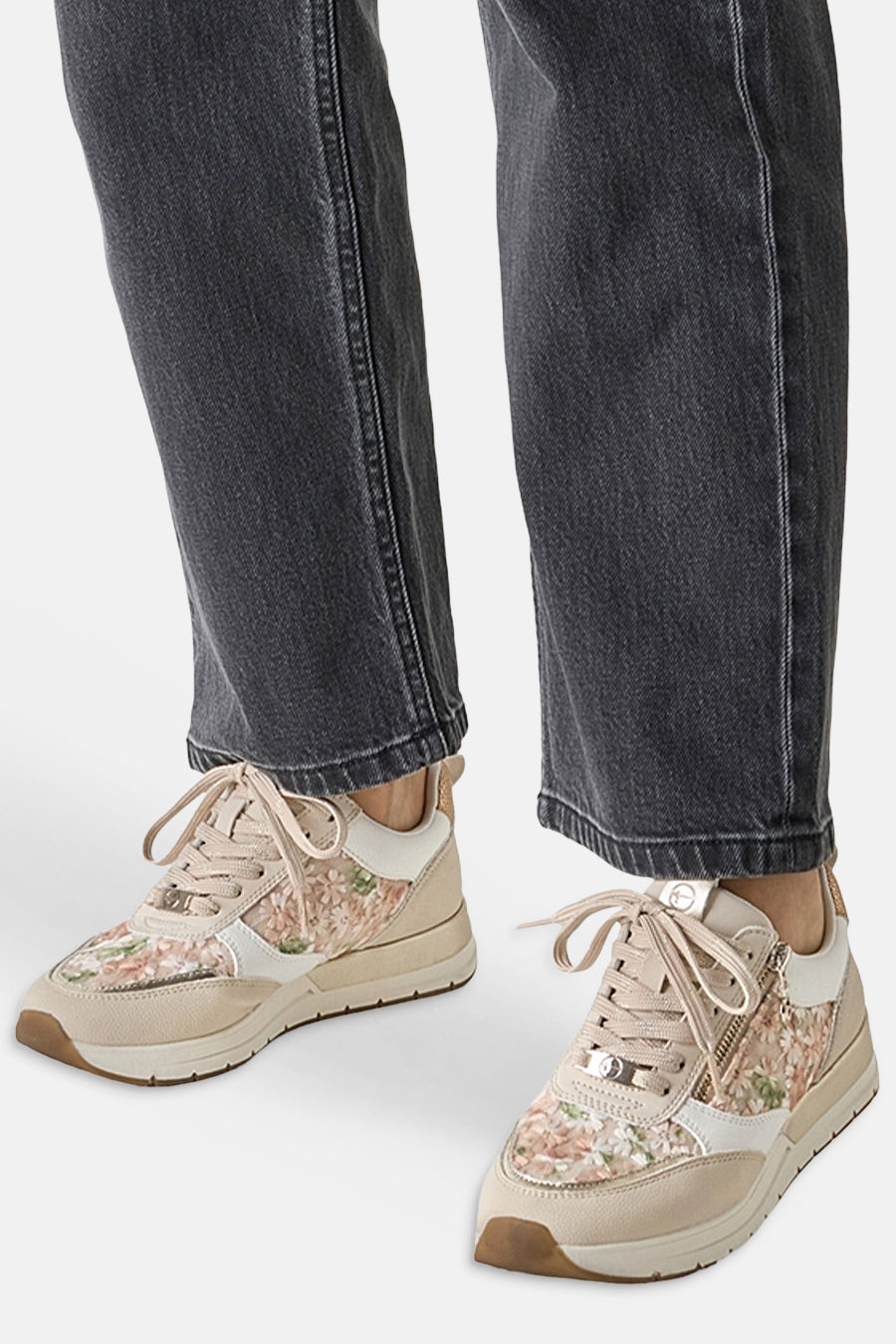 Beige Tamaris sneakers met een delicaat bloemenpatroon en een decoratieve ritssluiting.