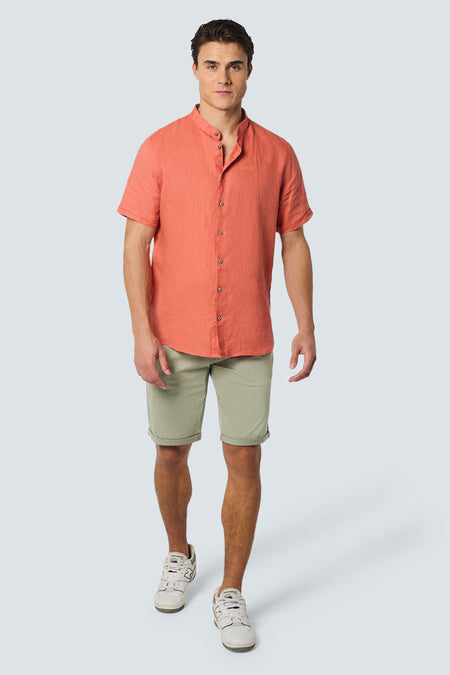 Korte kaki broek van NO EXCESS, gedragen met een oranje overhemd met korte mouwen en witte sneakers.