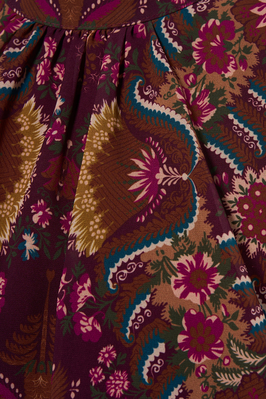 Multicolored sleeveless dress with floral and paisley pattern, featuring purple, teal, and gold tones in a close-up view