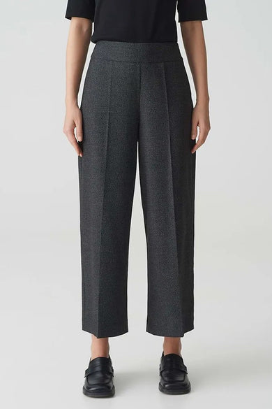 Grijs gemêleerde broek OPUS, wijde pasvorm, gedragen met een zwart T-shirt met korte mouwen en zwarte loafers, achterzicht.