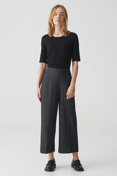 Antracietgrijze broek met wijde pijpen van OPUS, gedragen met een effen zwart T-shirt en platte schoenen.