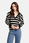 Pull à capuche multicolore de Morgan de Toi, à rayures horizontales noires et écrues, porté avec un jean taille haute à poches cargo.
