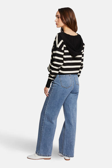 Pull à capuche multicolore de Morgan de Toi à rayures horizontales, porté avec un jean taille haute ample.
