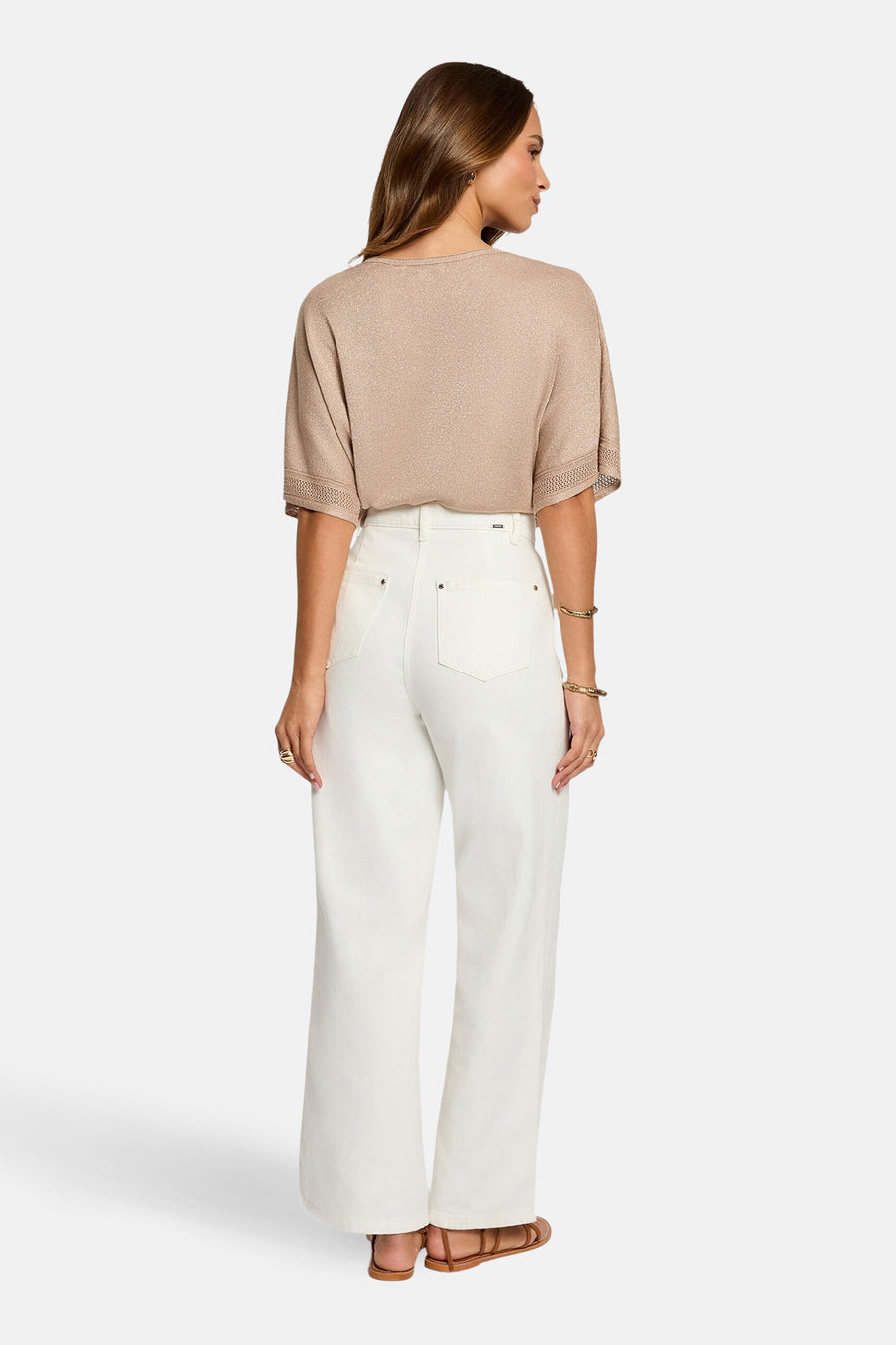 T-shirt à manches courtes beige de Morgan de Toi, avec manches ajourées, porté avec un jean blanc et des sandales marron.