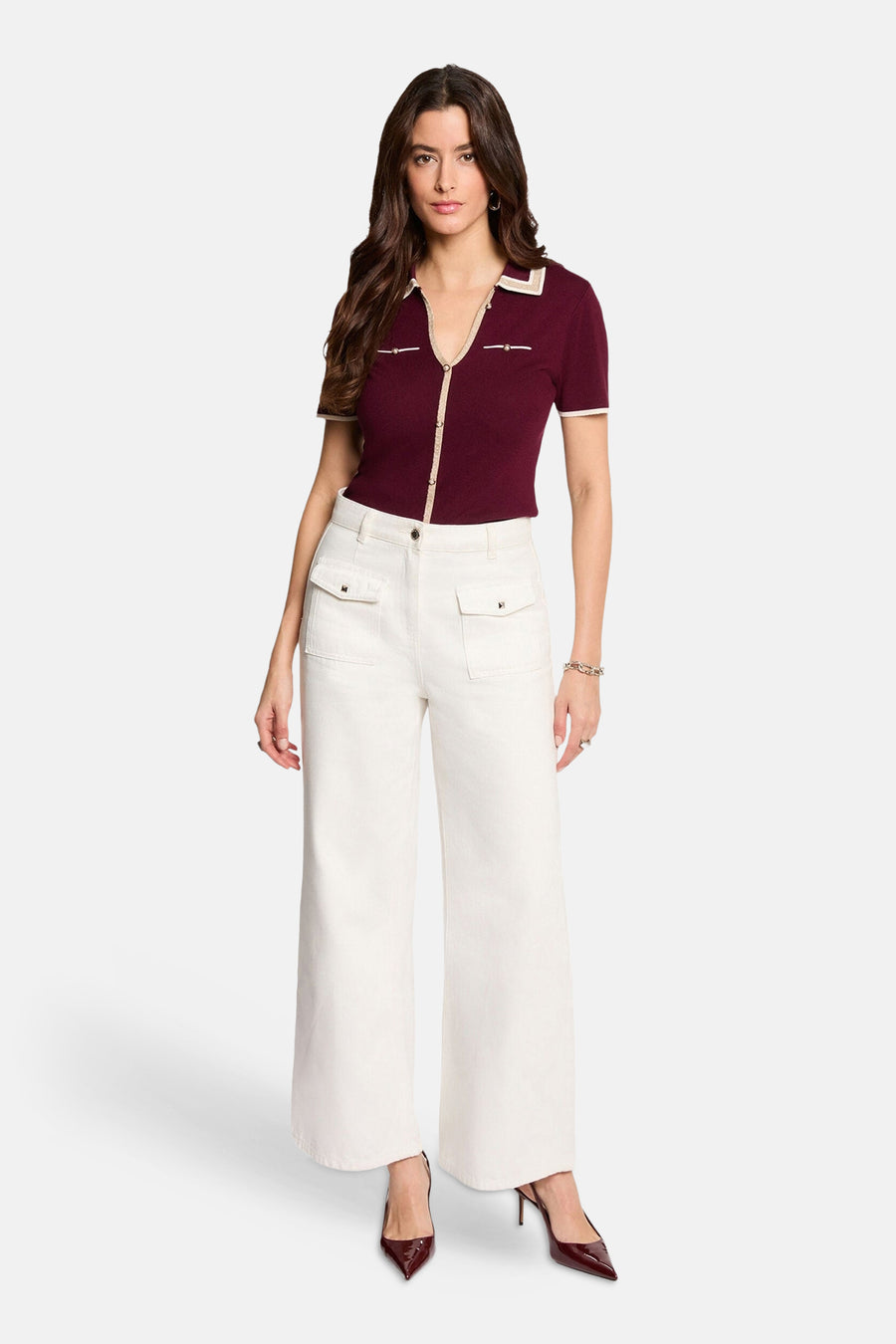 Bordeaux short-sleeve cardigan with cream trim and button front, worn with white wide-leg pants and matching heels, full-length front view