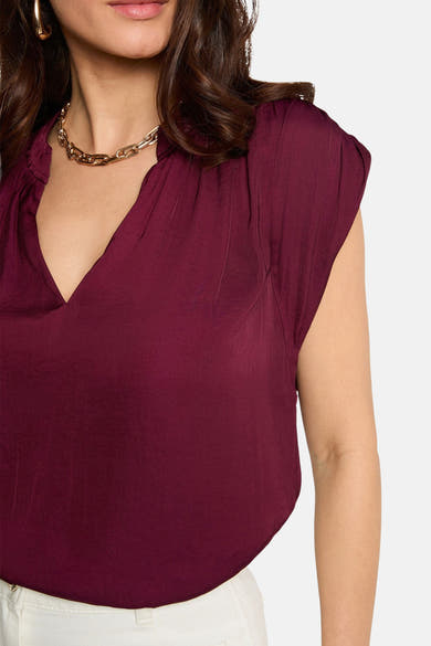 Chemisier bordeaux sans manches de Morgan de Toi avec un décolleté en V et un collier doré.
