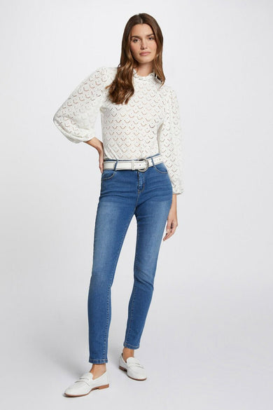 Jean slim en denim bleu moyen de Morgan de Toi, porté avec une ceinture blanche et des mocassins blancs.