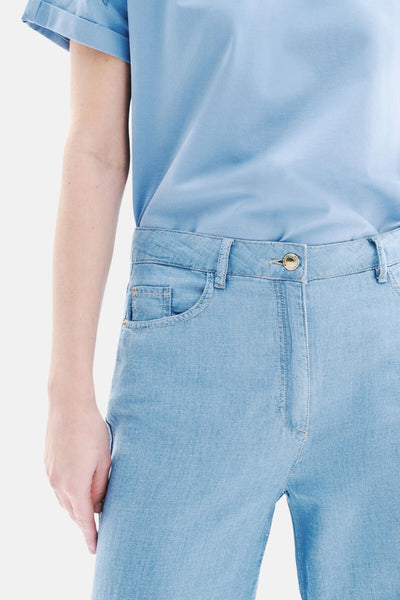 Pantalon en denim bleu clair de CAROLL, avec une poche avant et une boutonnière dorée.