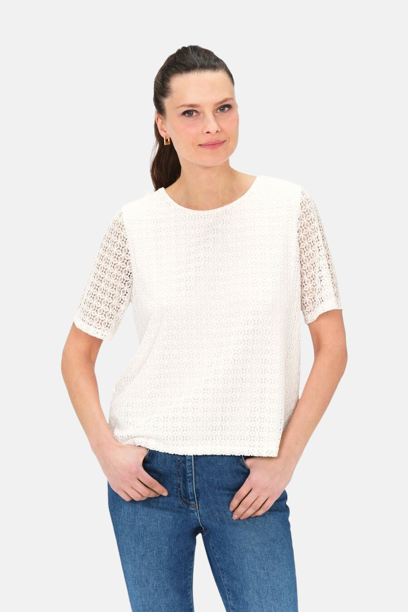 Wit T-shirt met korte mouwen van CAROLL, met opengewerkt patroon, gedragen met een blauwe jeans.