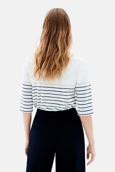 Witte rondehals trui van CAROLL, met marineblauwe strepen en driekwartmouwen, gedragen met een marineblauwe broek.