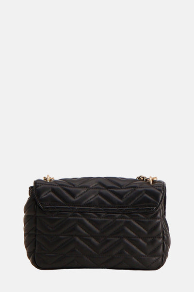 Sac à main noir par Morgan de Toi, avec motif matelassé à chevrons et chaîne dorée.