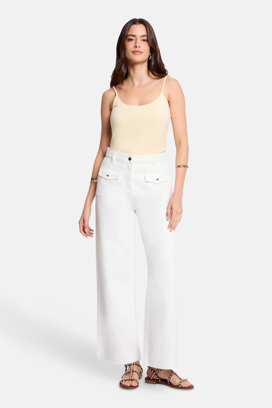 Gele top met dunne bandjes van Morgan de Toi, gedragen met een witte broek met hoge taille.